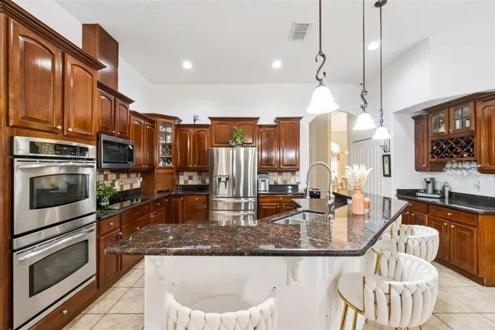 Kitchen with built-in oven, cooktop and built in bar