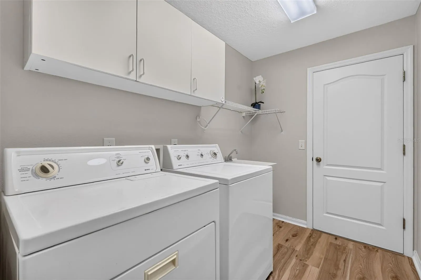 Laundry with set sink and plenty of storage.