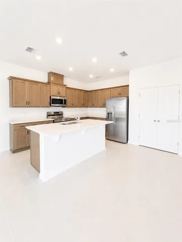 Spacious kitchen with quartz countertops, oversized island, and stainless steel appliances.