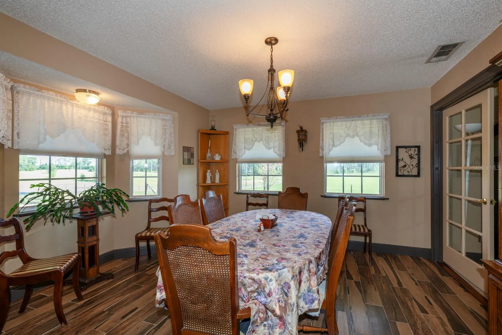 Spacious Dining Room with wood grain tile flooring and bay window