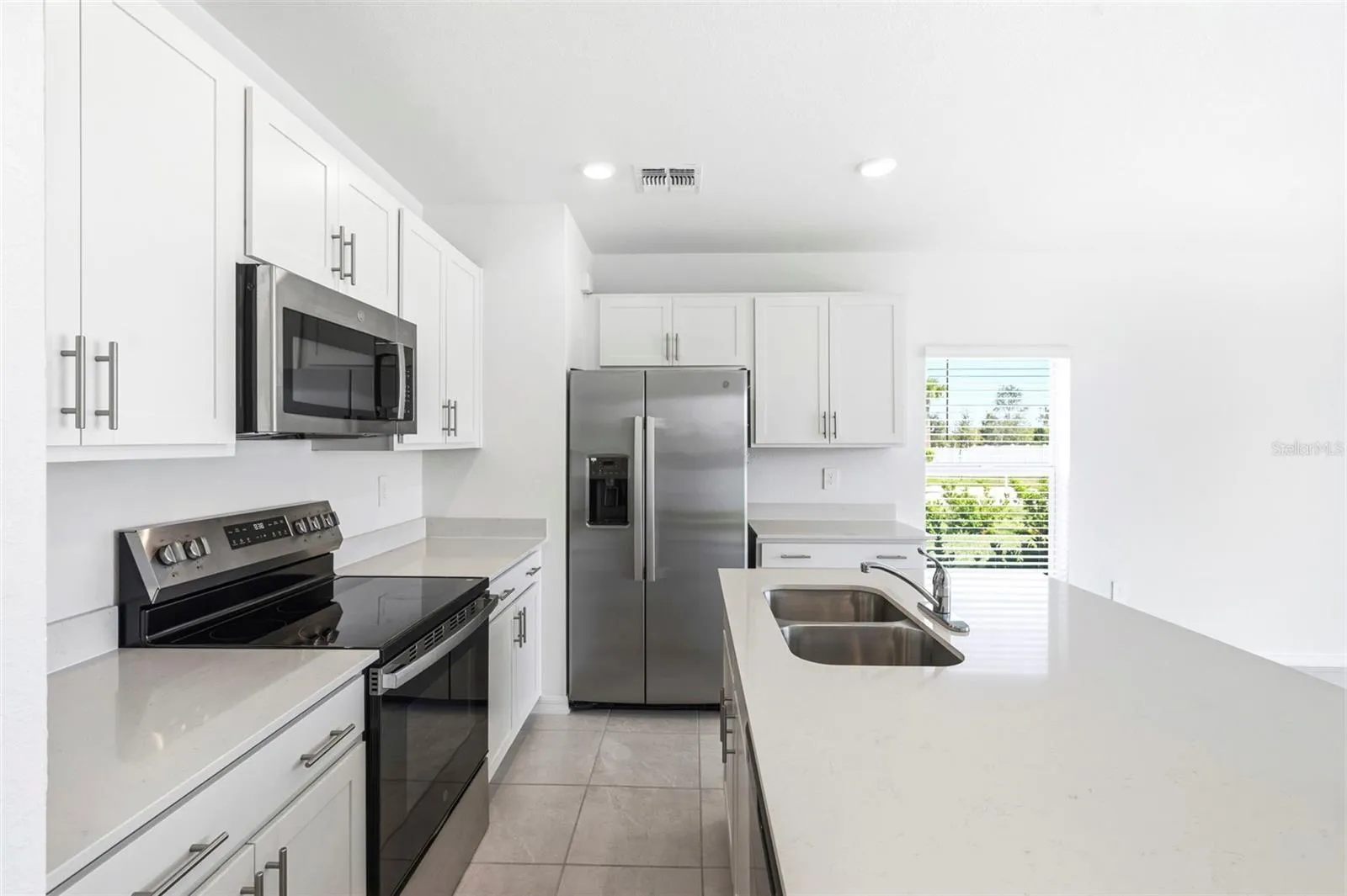 kitchen with double sink quartz island and stainless steel appliances