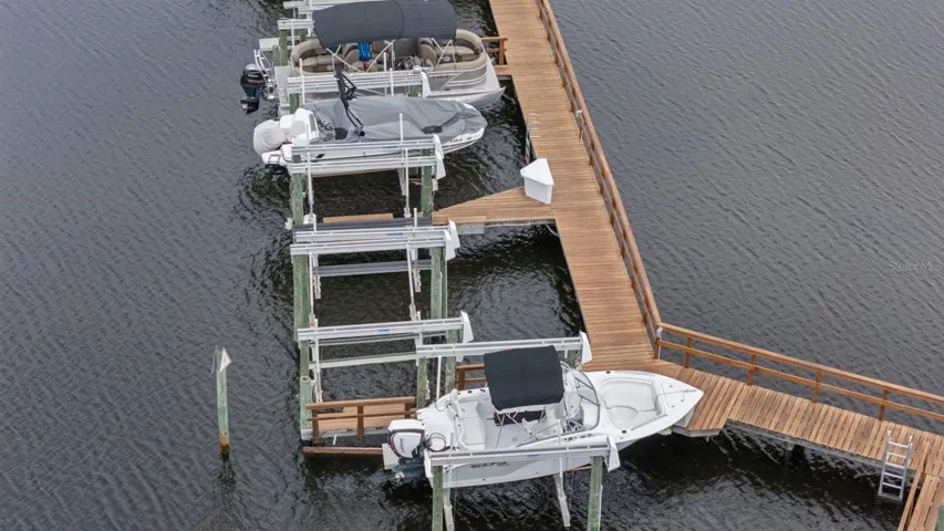 Boat lift #25 empty next to white boat with black bimini top
