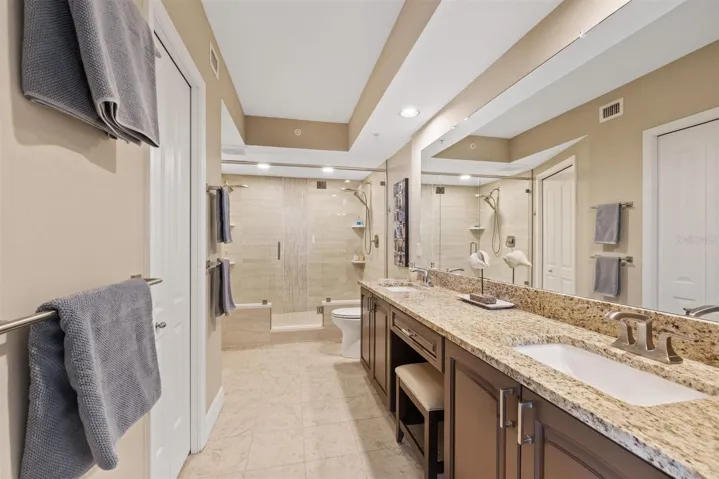 Renovated Primary ensuite bathroom with waterfall tile dual shower in glass enclosure