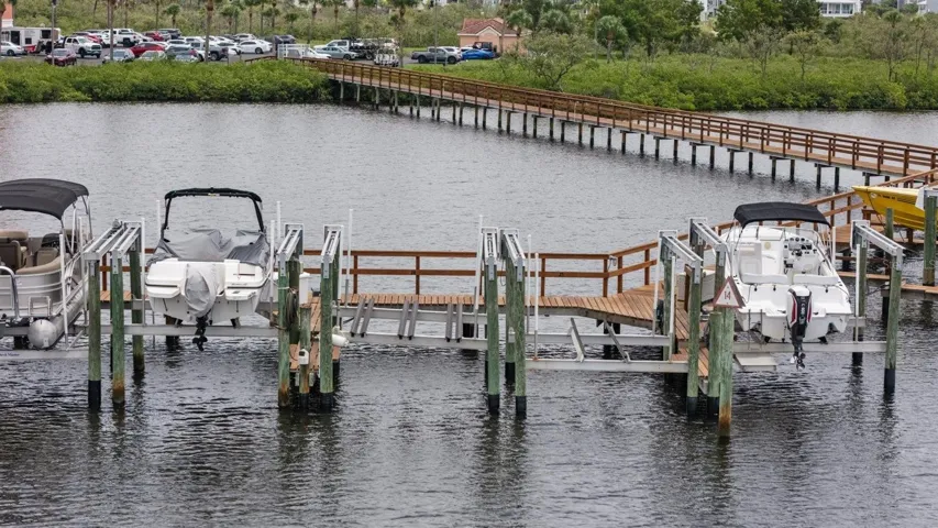 Boat lift #25 empty next to white boat with black bimini top