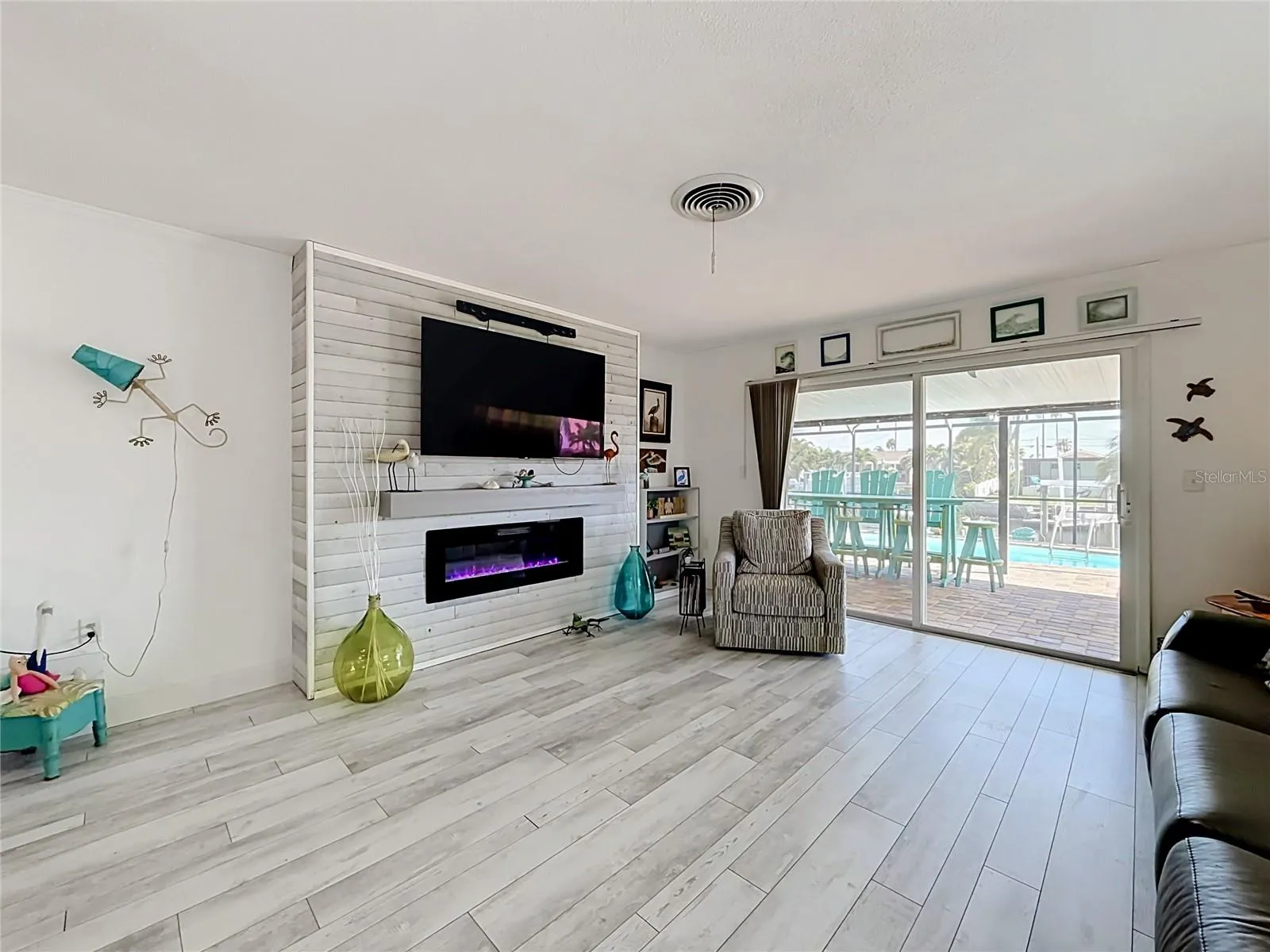 Luxury vinyl plank flooring is throughout this home.  A slider to the pool deck and electric fireplace make this a cozy place to chill