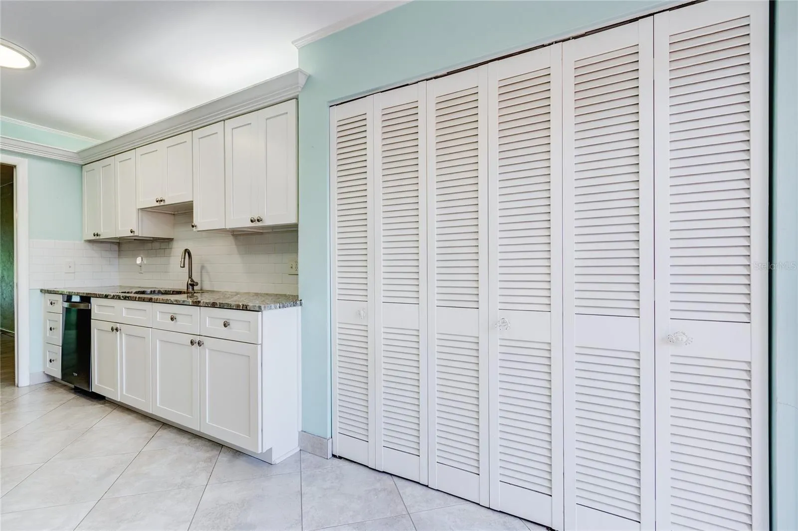 Huge bifold pantry. Notive the uplit crown molding.