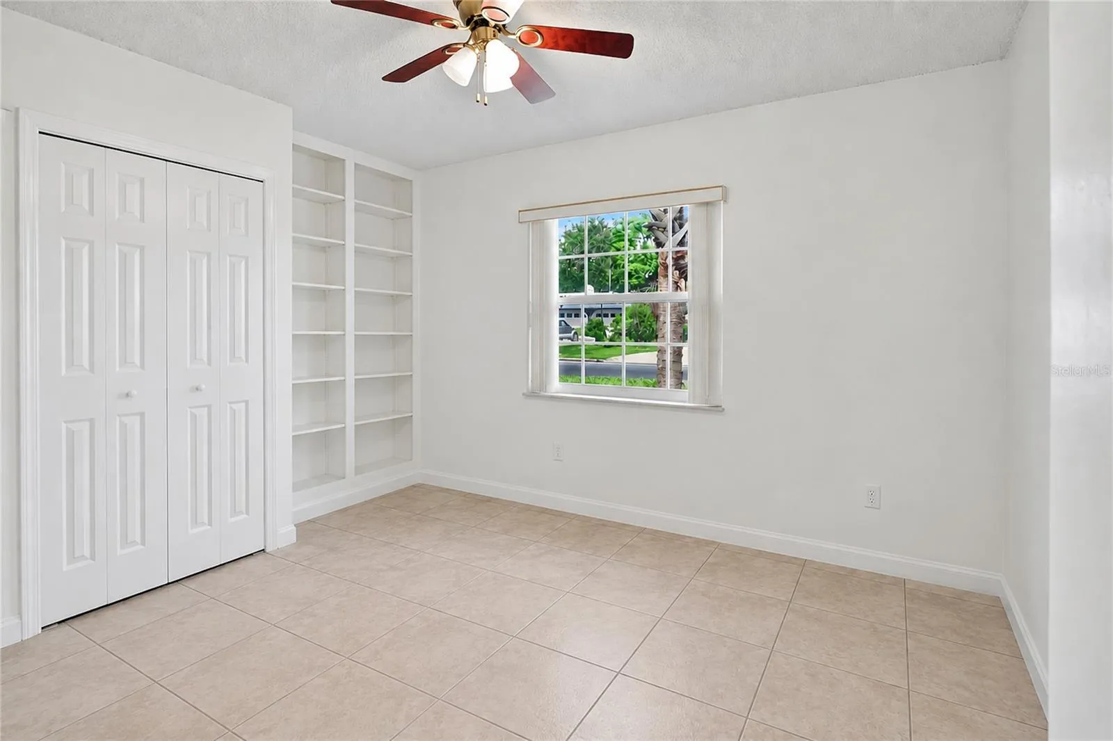 Bedroom 2 with built-in shelving.