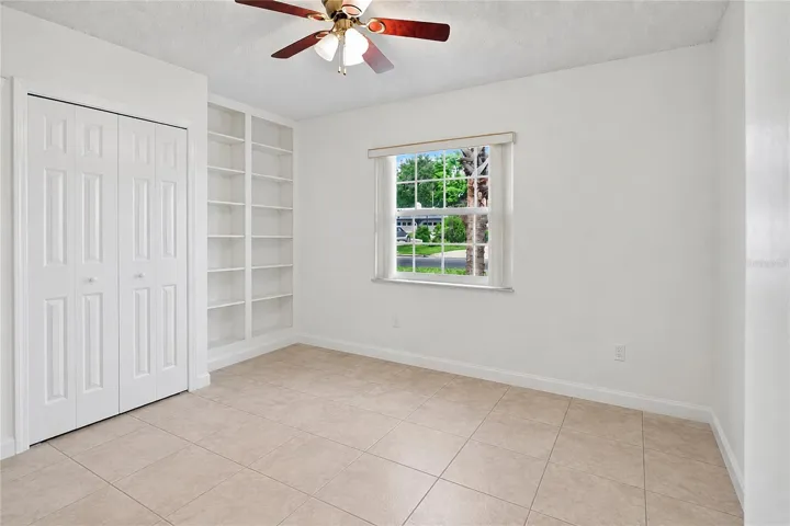 Bedroom 2 with built-in shelving.