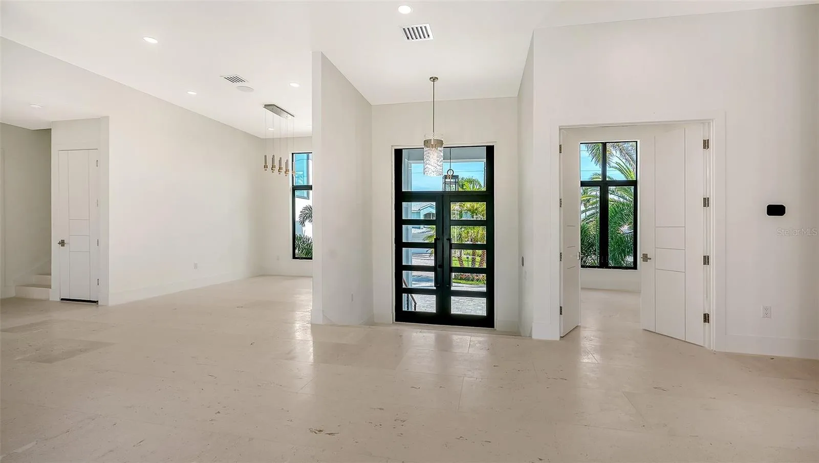 Framed by a custom CGI front door, the grand foyer showcases soaring ceilings, timeless coastal elegance, and a seamless flow into the home’s beautifully designed living spaces.