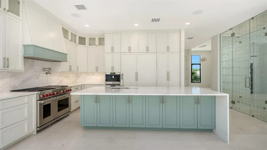 Equal parts beautiful and functional, the chef’s kitchen is impeccably appointed with Wolf and Sub-Zero appliances, a built-in Wolf coffee system, Cove dishwasher, custom cabinetry, an oversized island, and a 9-foot entertaining bar.