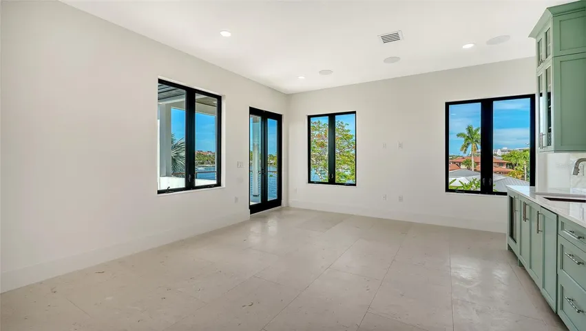 The expansive top-floor bonus room features a custom beverage bar, private balcony, and sweeping water views, creating an exceptional space for entertaining, relaxing, or enjoying the coastal lifestyle.