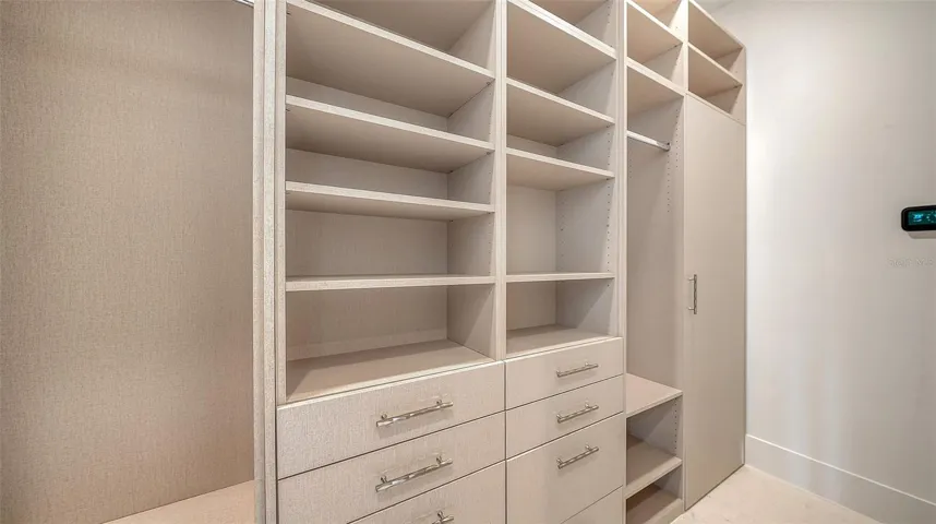 The second of two custom walk-in closets is thoughtfully appointed with extensive built-ins, generous shelving, and dedicated storage throughout.