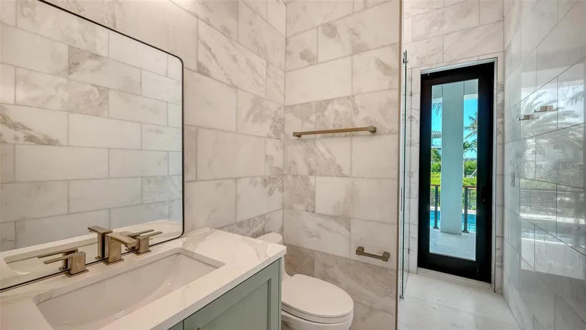 Finished in stunning floor-to-ceiling marble, the pool bath provides direct access to the lanai and resort-style pool, allowing guests to transition effortlessly between indoor luxury and outdoor waterfront living.