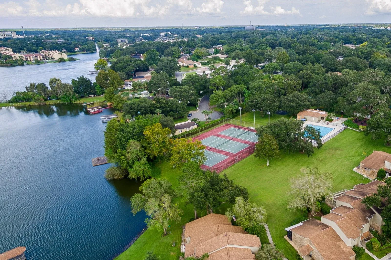 Aerial view of tennis courts, pool, and community