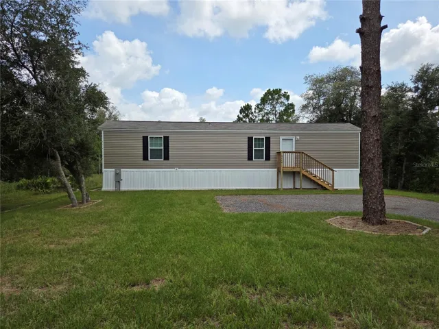 Front exterior view of the property featuring a manicured lawn and inviting entrance.