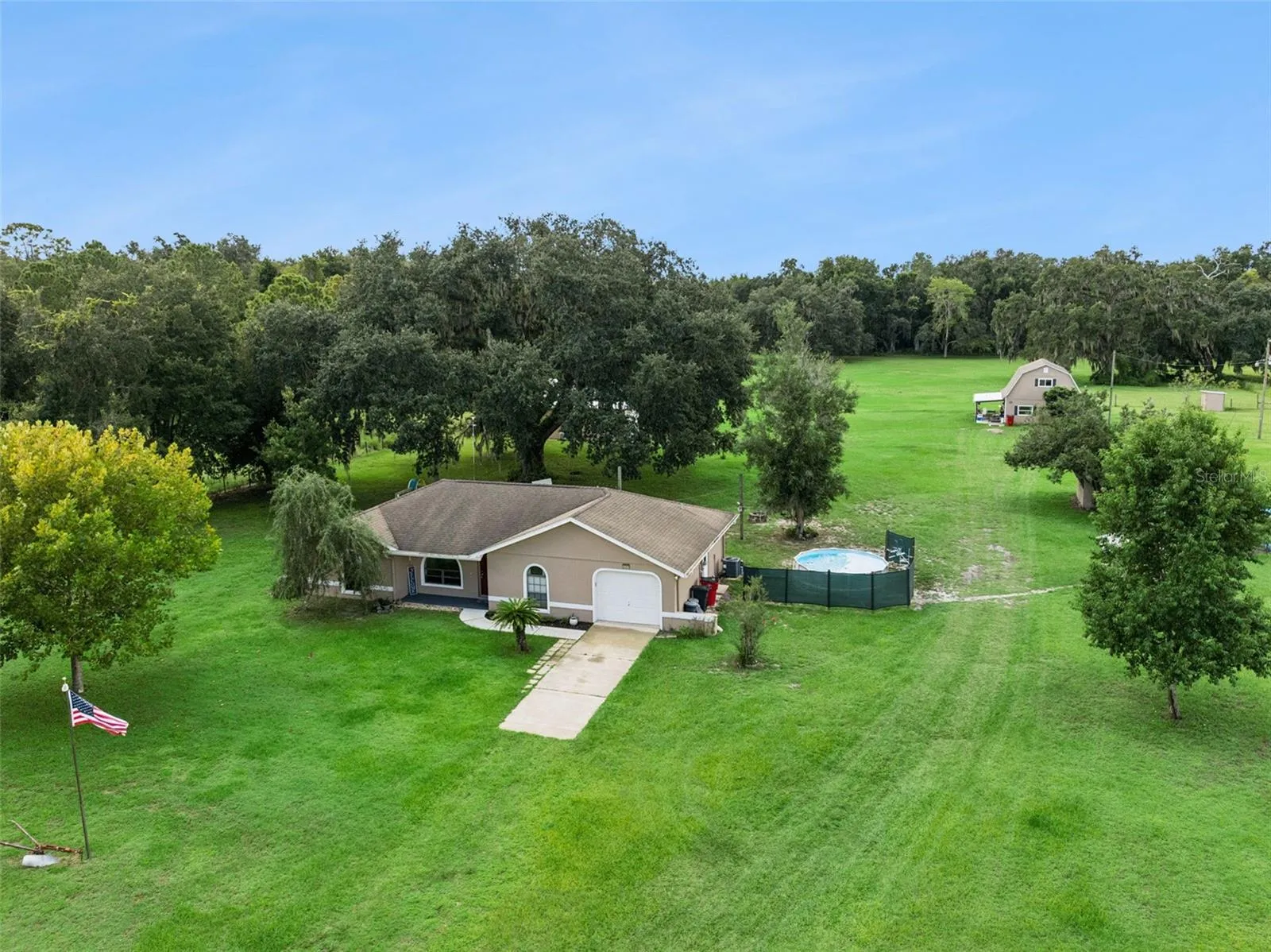 Area view of property featuring main home, pole barn, second building with apartment downstairs and office space or game room upstairs, chicken coop, and so much more