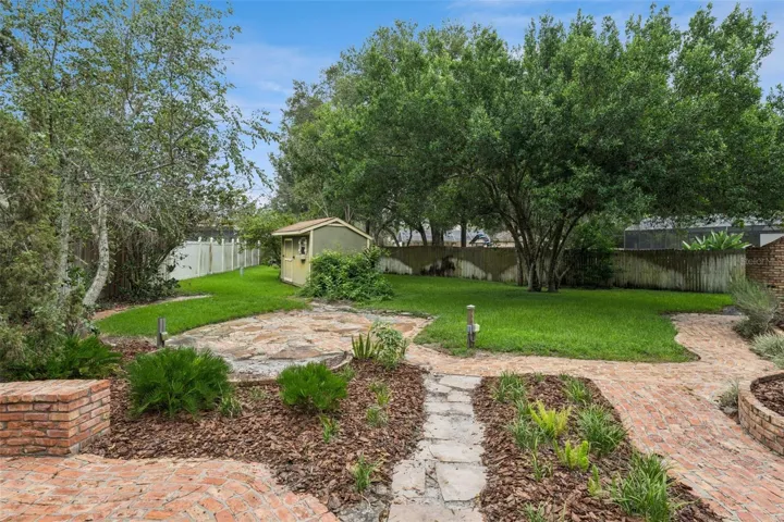 Lush Landscaping with plenty of grassy areas and large storage shed.