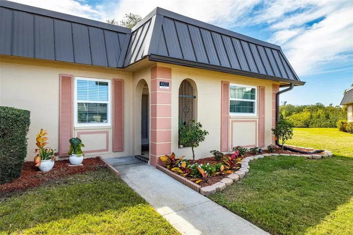 A covered, arched entry and decorative security door welcome you home, while the end-unit setting provides additional lawn space, natural light, and greater separation from neighboring residences.