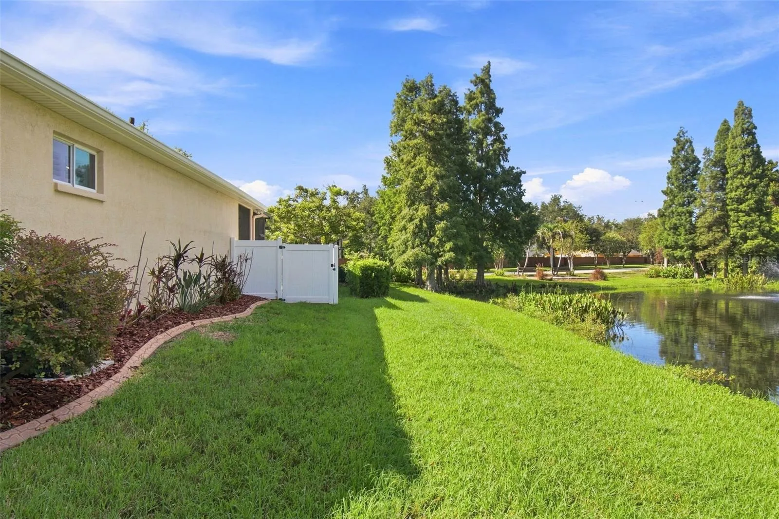 Side yard abutting the pond with fountain that is owned and maintained by the CDD.