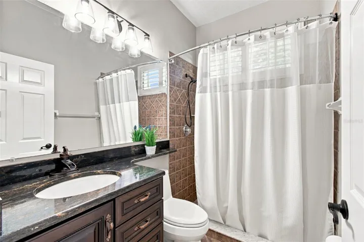 Guest bathroom is the 3rd full bath with updated granite, soft-close cabinet door and drawers, new light fixture and a walk-in shower