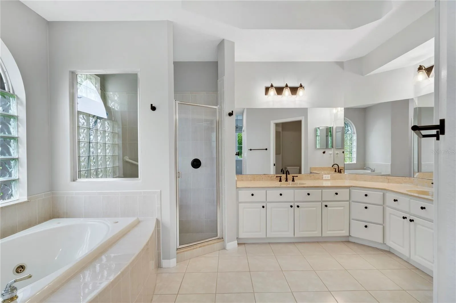 PRIMARY BATHROOM/ DUAL SINKS / NEW FIXTURES TILE FLOOR/ SEPARATE LOU (TOILET) W/DOOR AREA