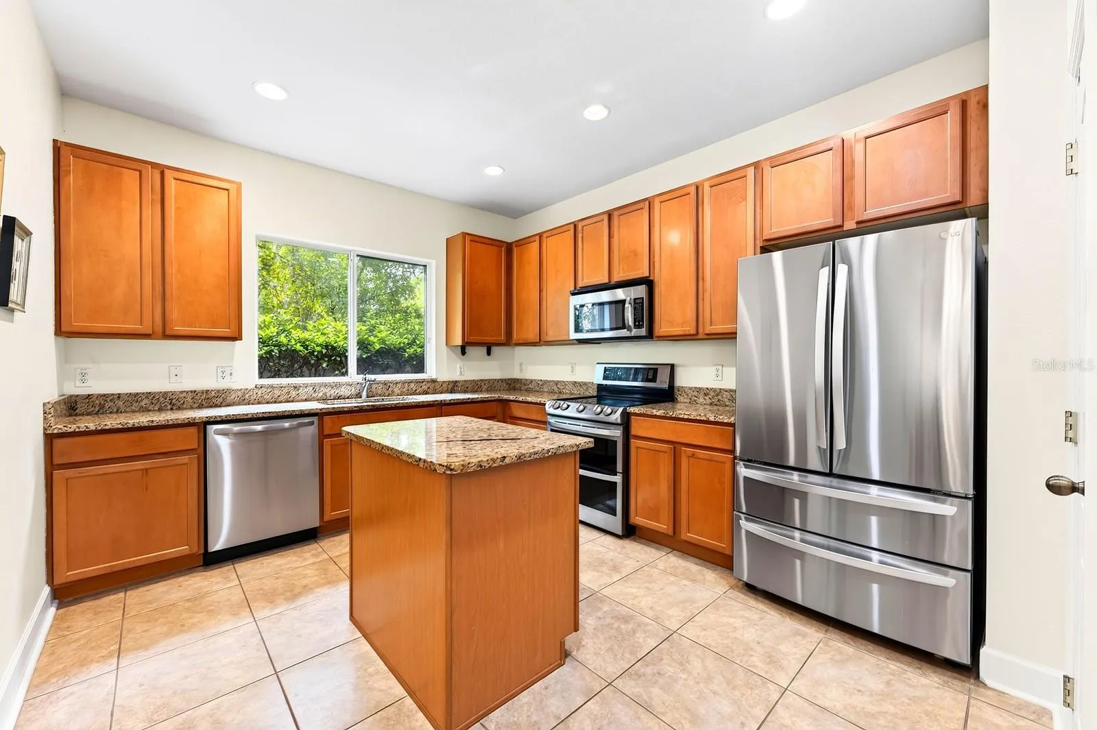The spacious kitchen is designed to keep everyone connected, featuring ample cabinet and counter space, a center prep ISLAND, upgraded STAINLESS STEEL APPLIANCES, pantry storage, and a window over the sink overlooking the backyard.