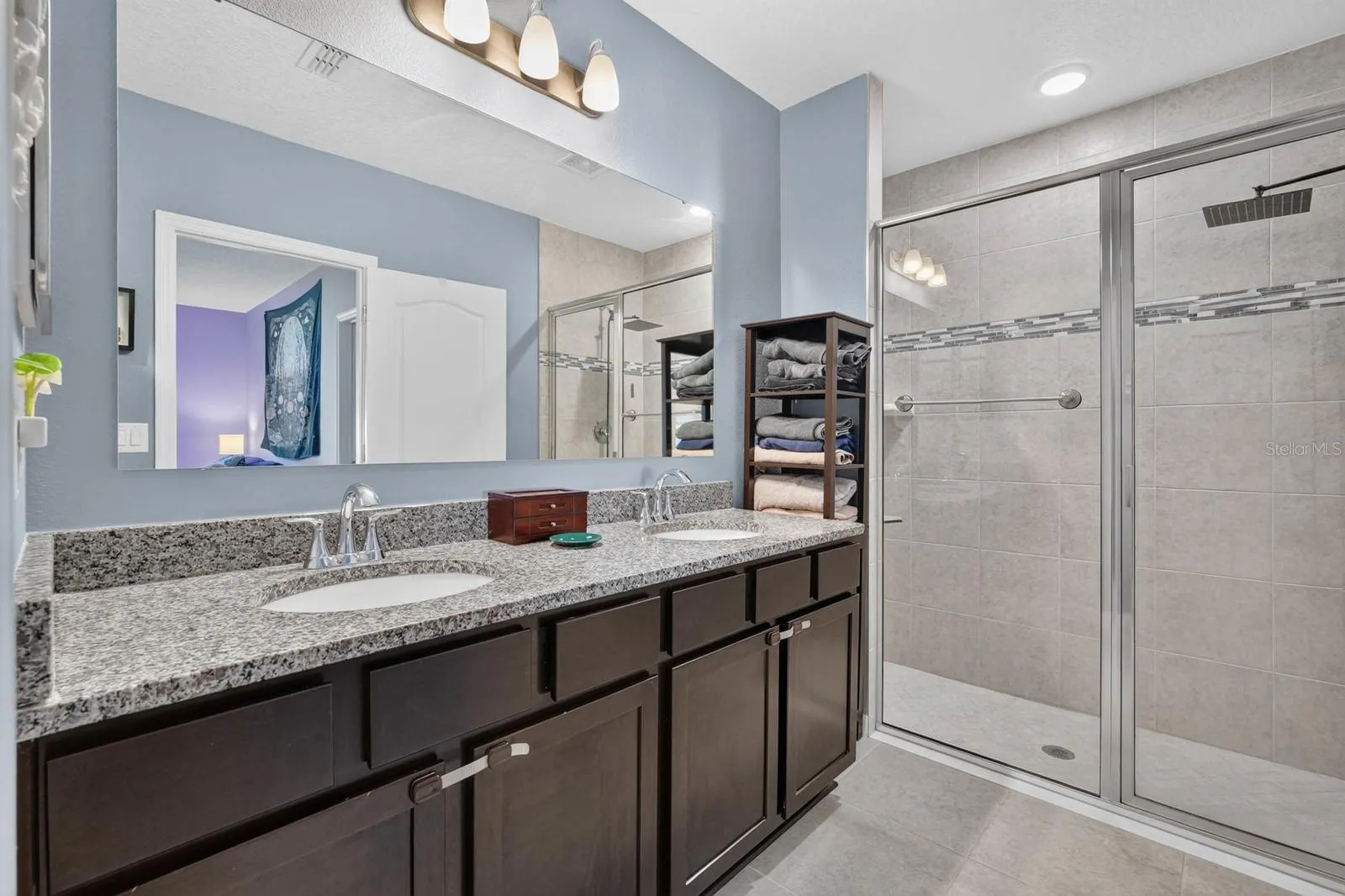 Ensuite bathroom features double vanity sinks and granite counters plus tiled shower with glass door
