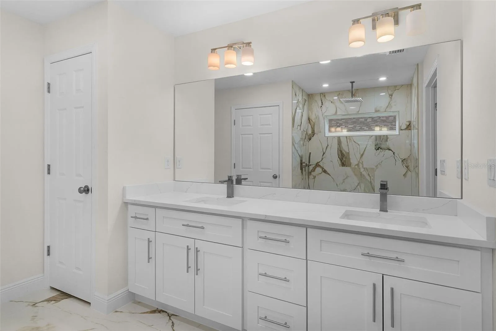 Primary En Suite- Double sinks, linen closet, beautiful ceramic tile on floor and shower.