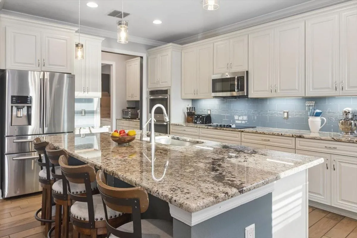 The kitchen features a spacious island with comfortable seating, creating the perfect spot for casual meals, morning coffee, or gathering with family and friends.