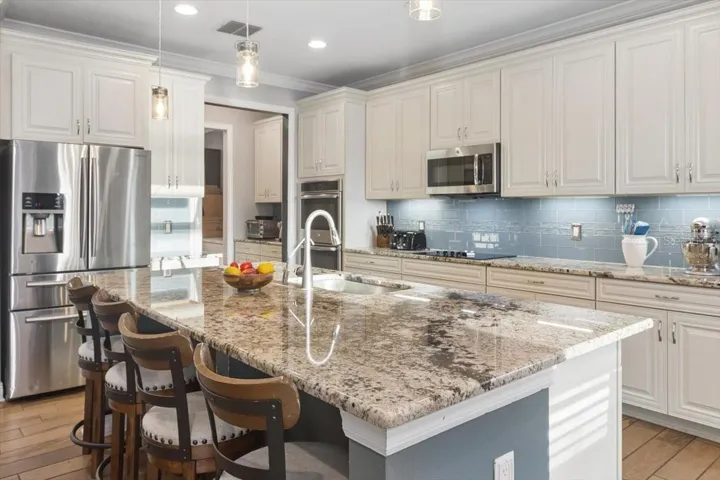 The kitchen features a spacious island with comfortable seating, creating the perfect spot for casual meals, morning coffee, or gathering with family and friends.
