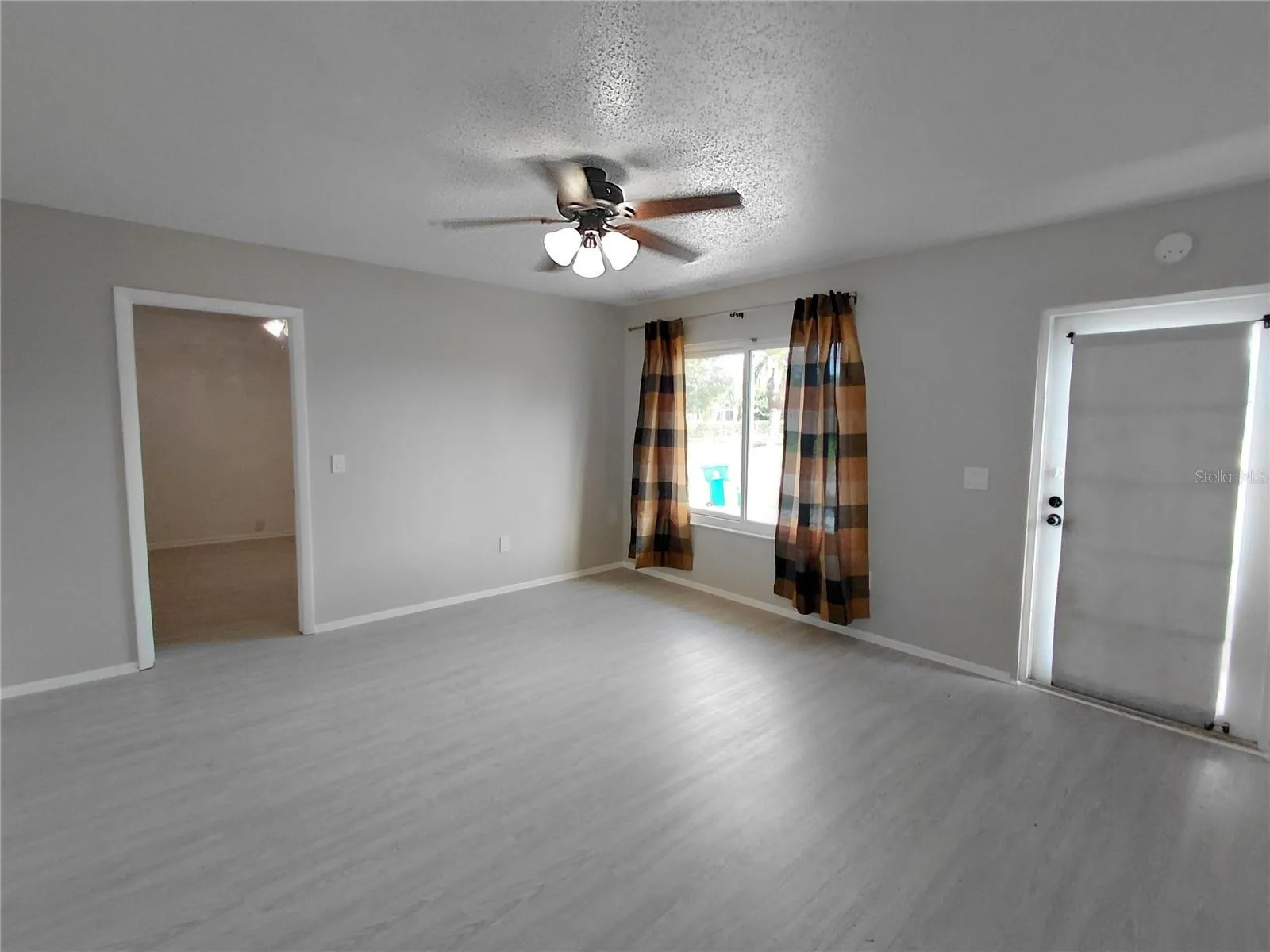 Front of home Living room with one of three bedrooms to the side.