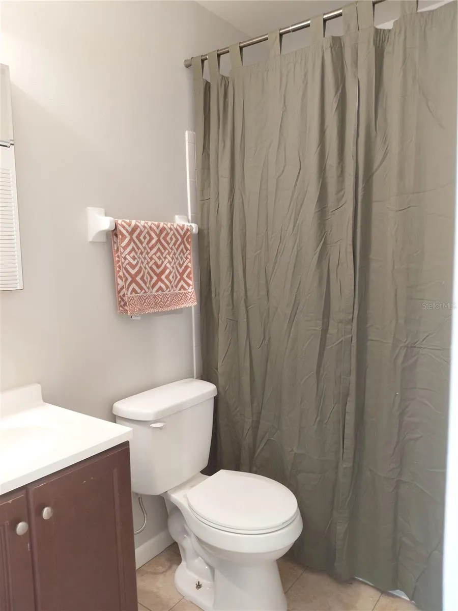 Guest Bathroom with tub Shower combo and linen storage.