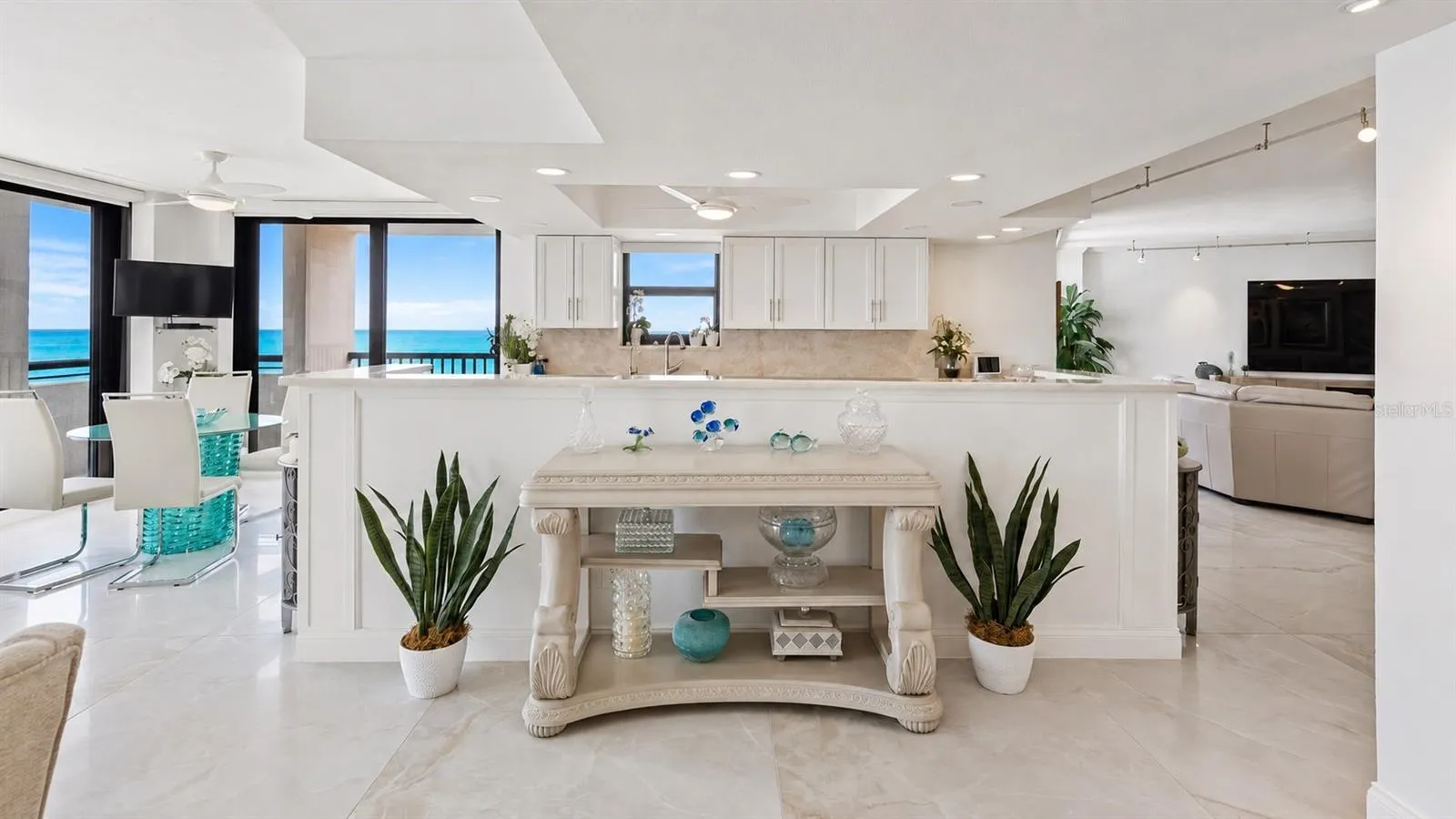 View from the dining area into the chef's kitchen with panoramic views of the sugar-sand beach and the gentle gulf waters beyond.