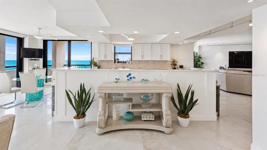View from the dining area into the chef's kitchen with panoramic views of the sugar-sand beach and the gentle gulf waters beyond.