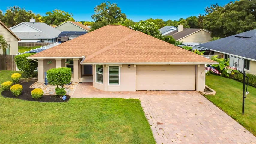 Front elevation with paver brick driveway and additional pavered front porch sitting area