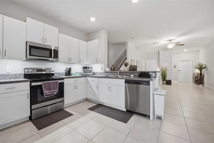 White kitchen with stainless appliances is OPEN to Great room