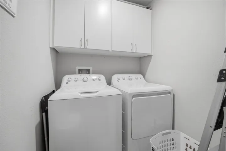 Washer and dryer with cabinets above in laundry room