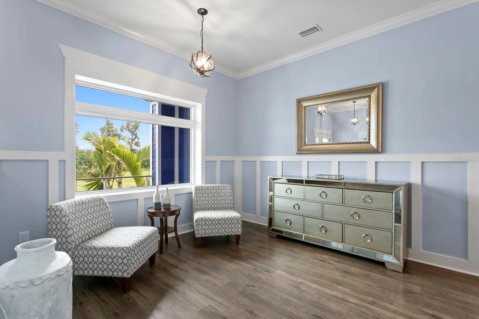 Living room features large portrait window and crown molding
