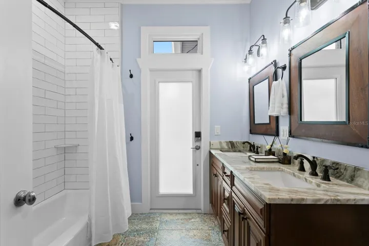 2nd Bathroom/Pool bath with ceramic tile floor, granite counters and door leading to pool