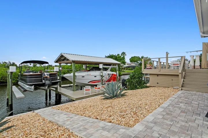 Paver walkway leads from deck down to covered boat lift