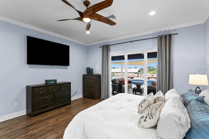 Primary bedroom features ceiling fan and crown molding