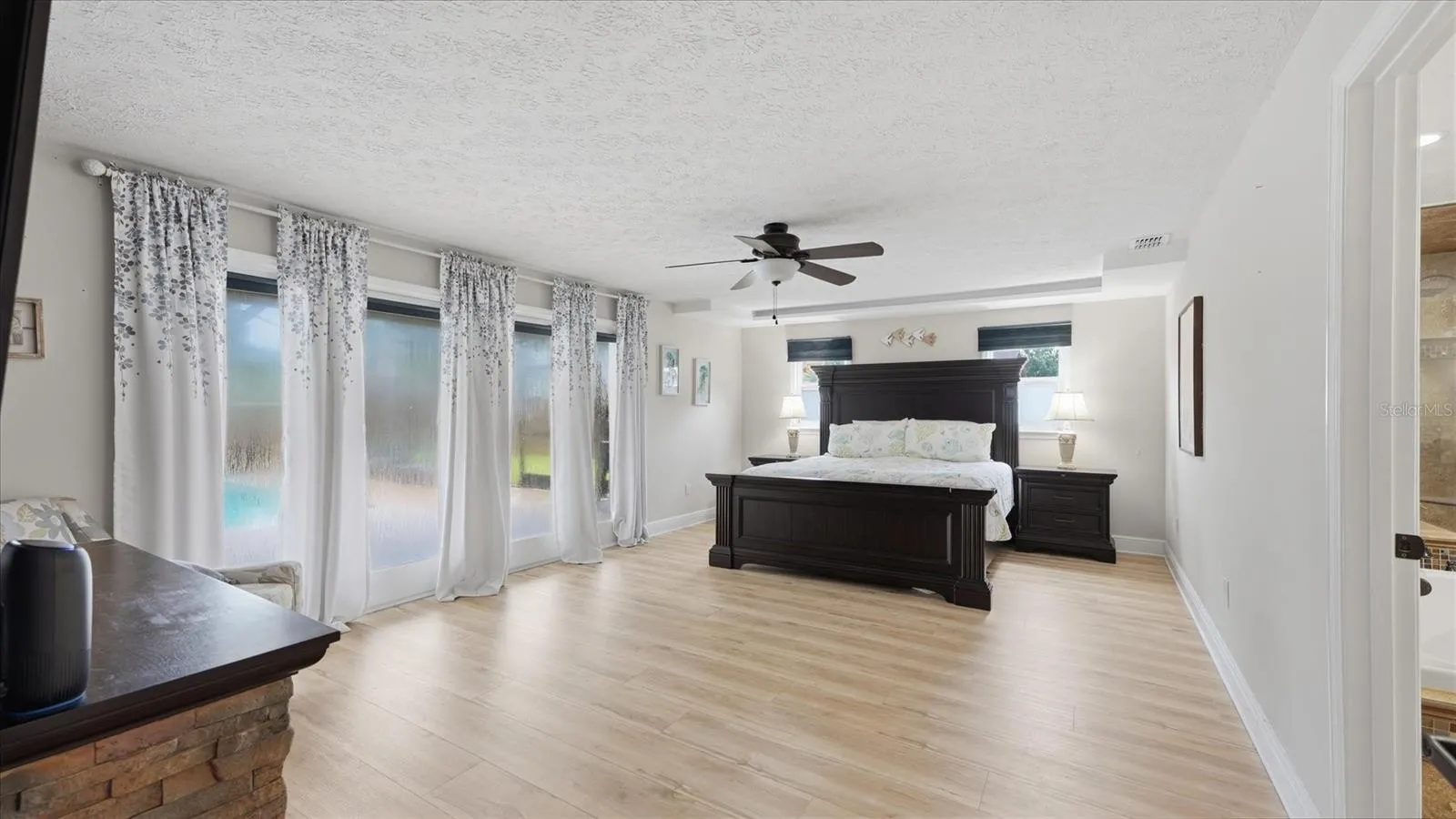 Primary suite offers access to the patio/pool through French Doors