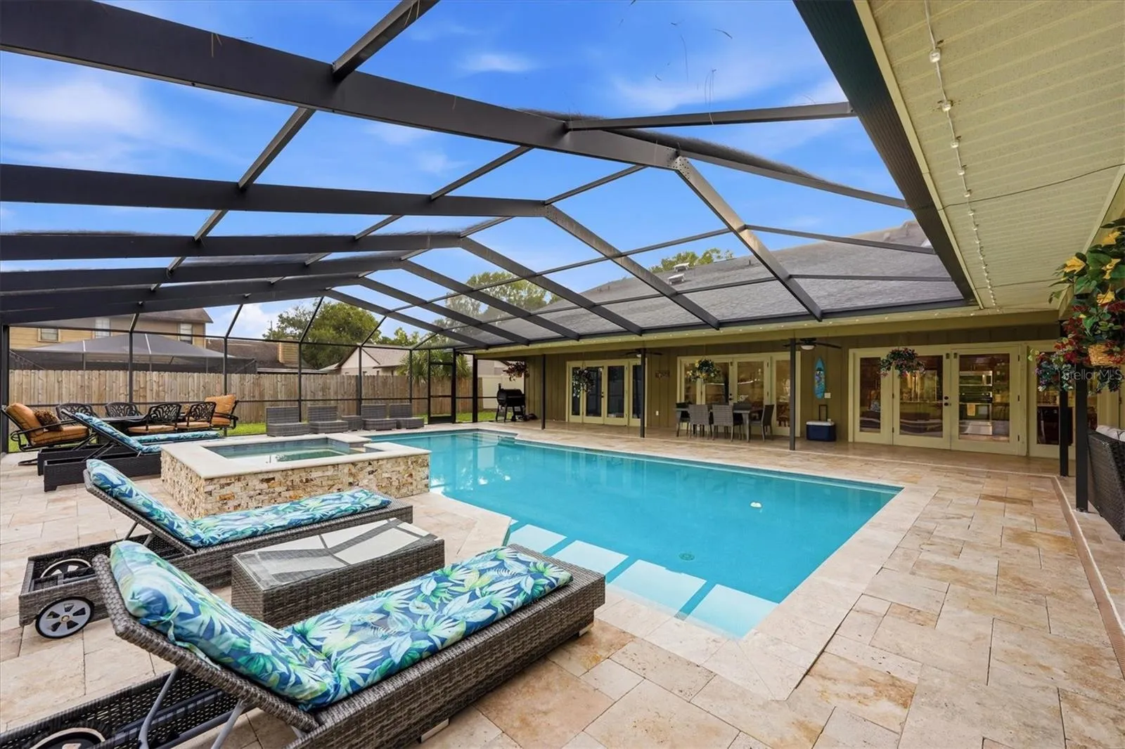 Inviting oversized pool with elevated spillover spa and plenty of seating for guests