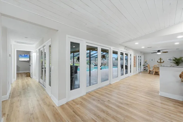 Wall to wall French Doors &amp; windows provide clear view to pool and patio!  Hallway leads to bedroom 4 and adjoining full bath.