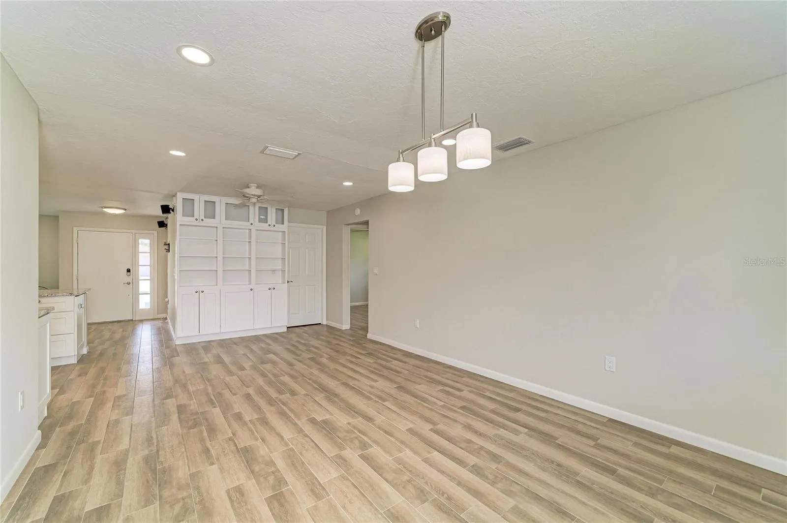 Large dining room off the kitchen with built-in shelves and cabinets.