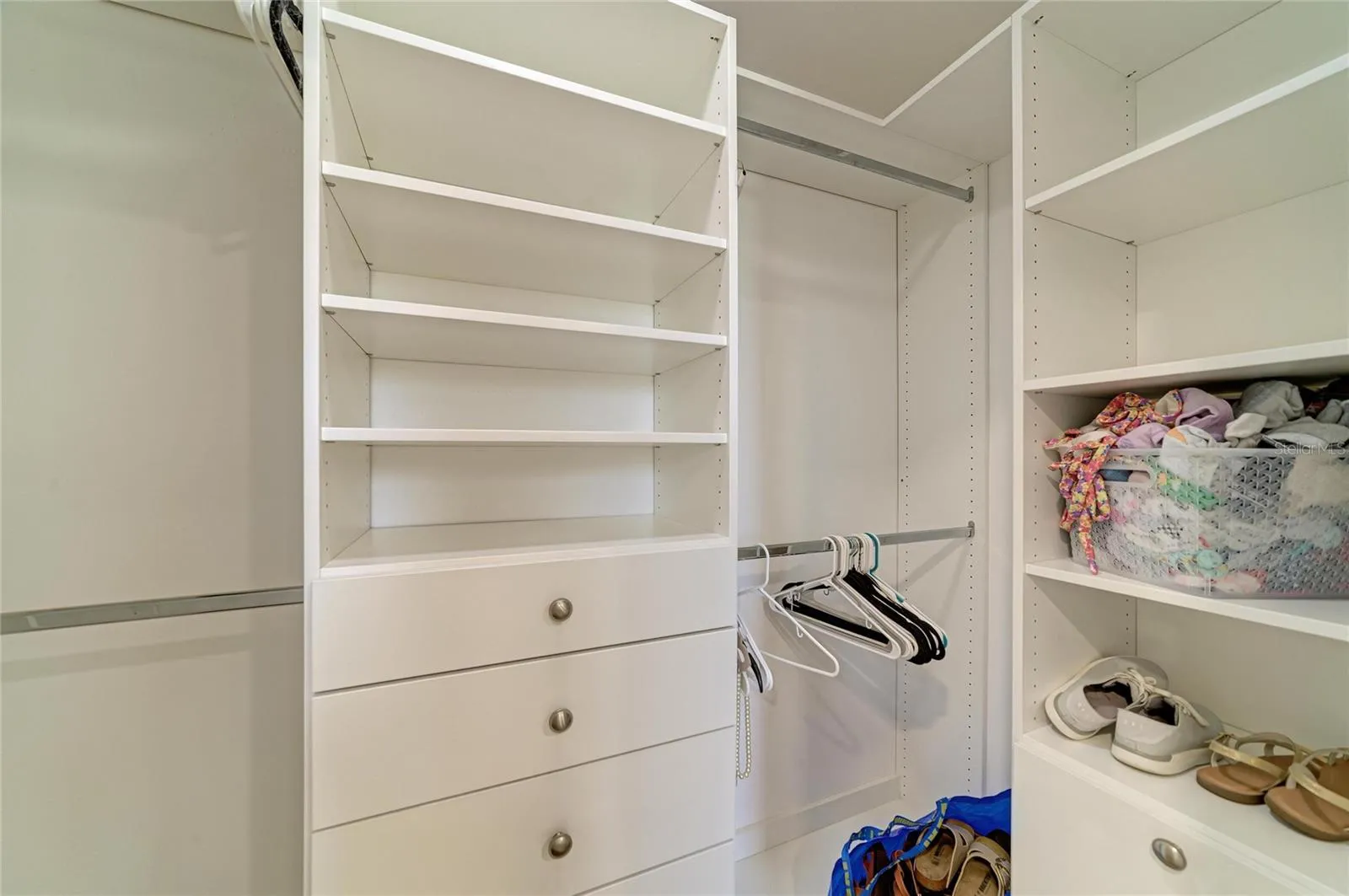 Primary bedroom walk-in closet with custom shelving.