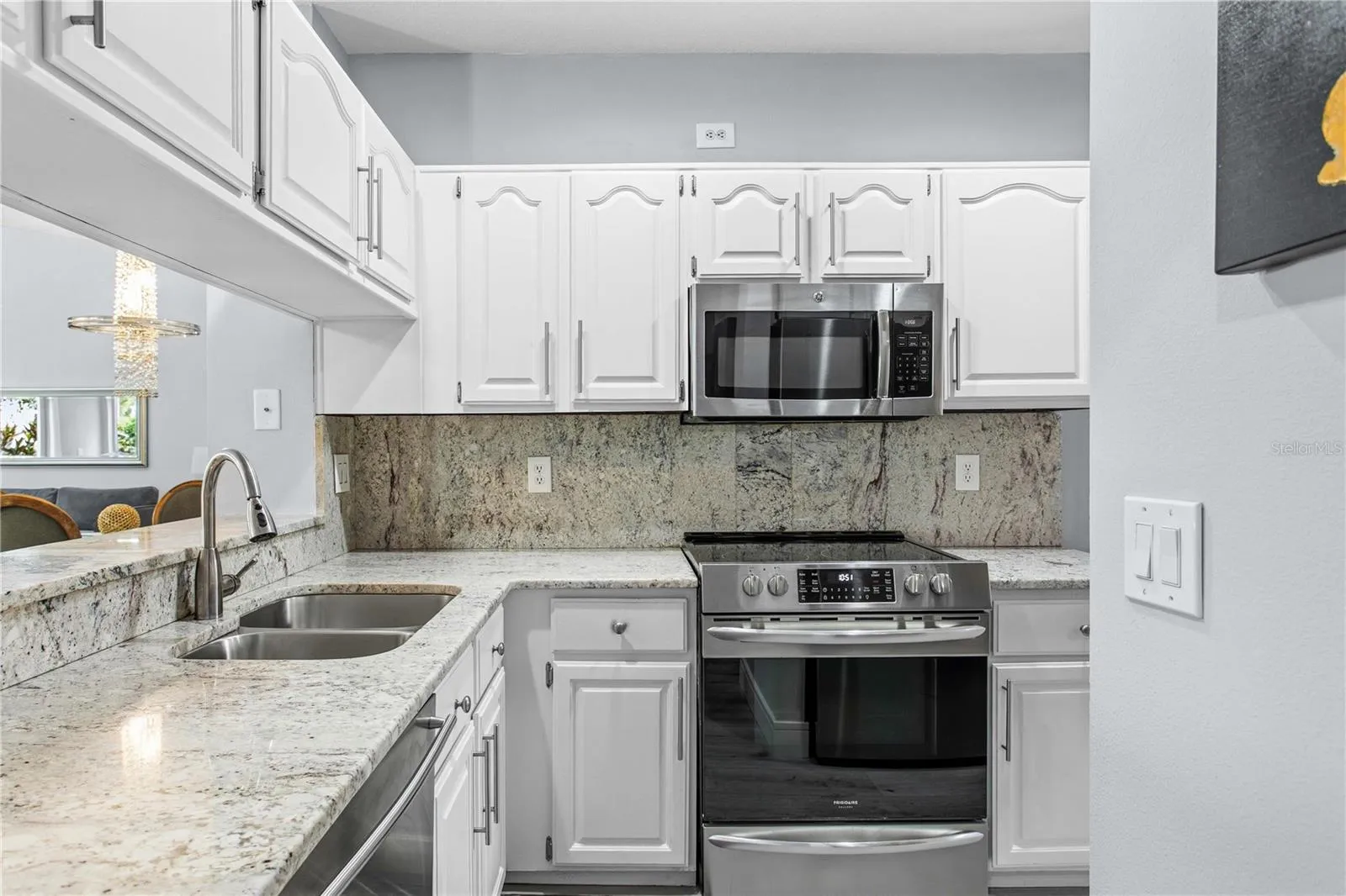 The light filled kitchen features stainless steel appliances and granite countertops.