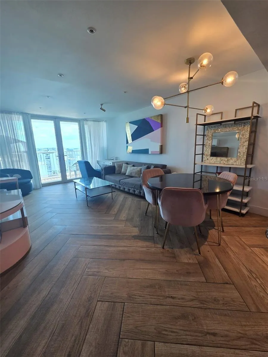 Open plan dining/living looking from the kitchen to the balcony doors.