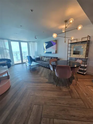 Open plan dining/living looking from the kitchen to the balcony doors.