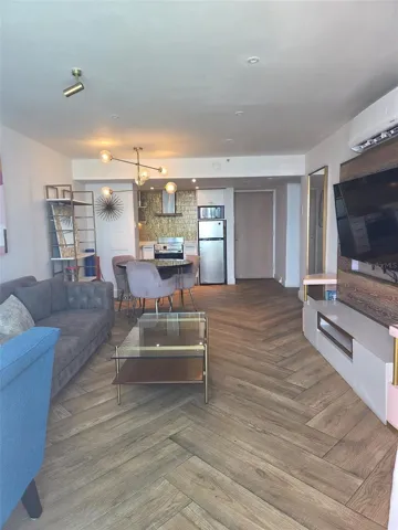 View from the balcony door showing the kitchen and front entrance (at far right). Floors are ceramic tile for easy maintenance.